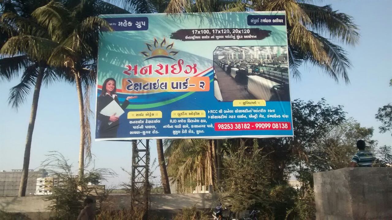 Sunrise Textile Park hoarding beside a road in Surat
