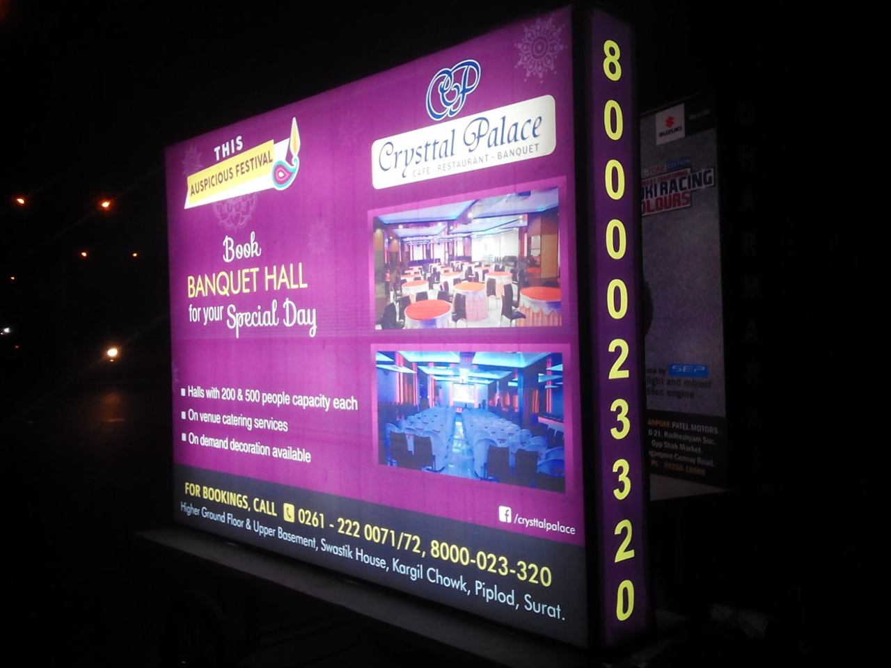 Illuminated backlit advertising board at night in Surat
